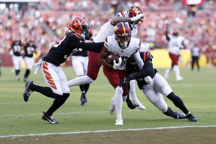 Washington Commanders wide receiver Mitchell Tinsley (86) scores a touchdown as Cincinnati Bengals linebacker Markus Bailey (51) defends during the second quarter at FedExField.